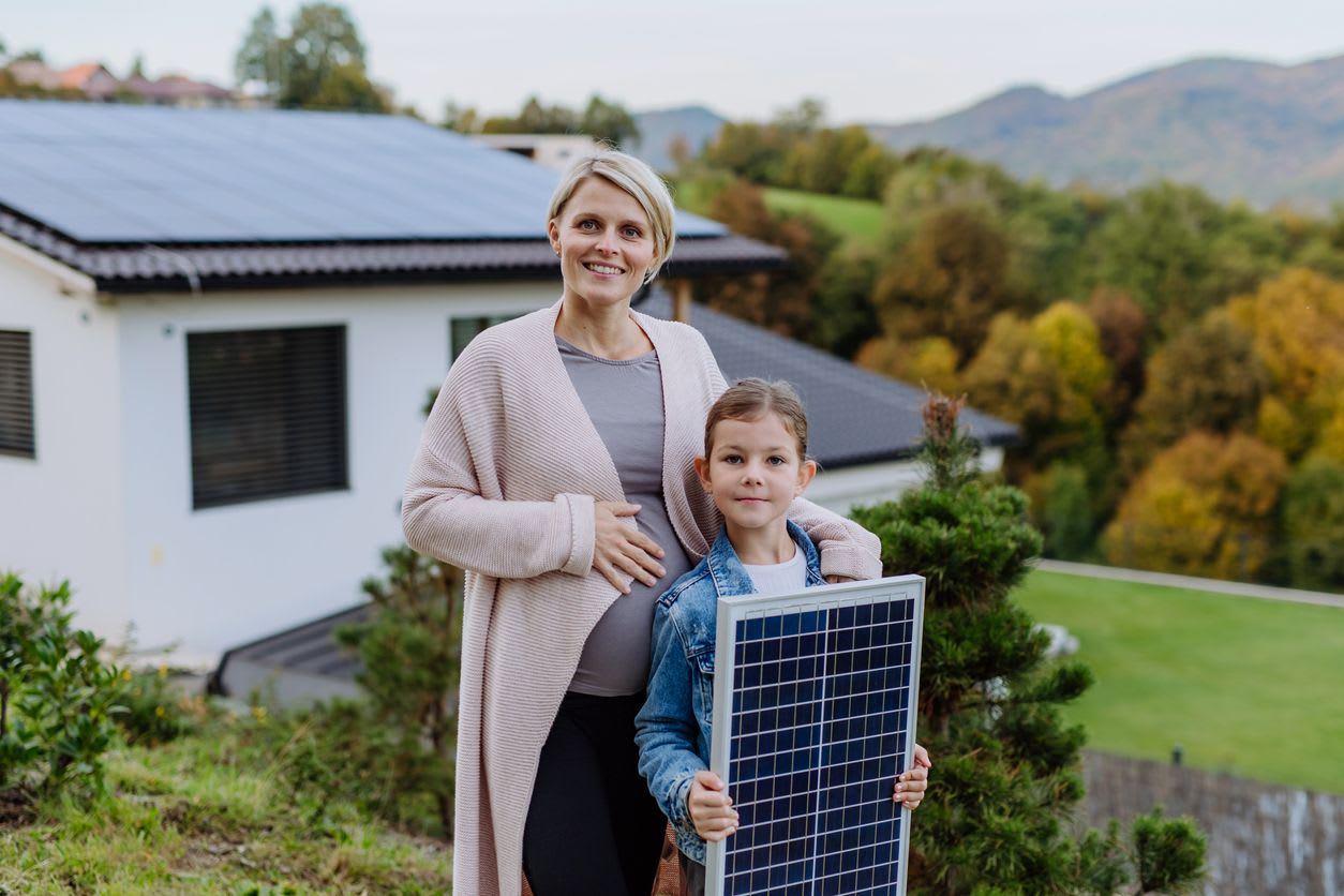 Family holding a solar panel