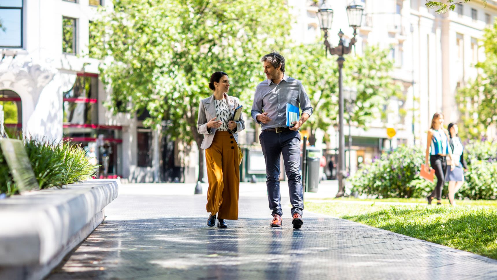 man and woman discussing work while walking outside