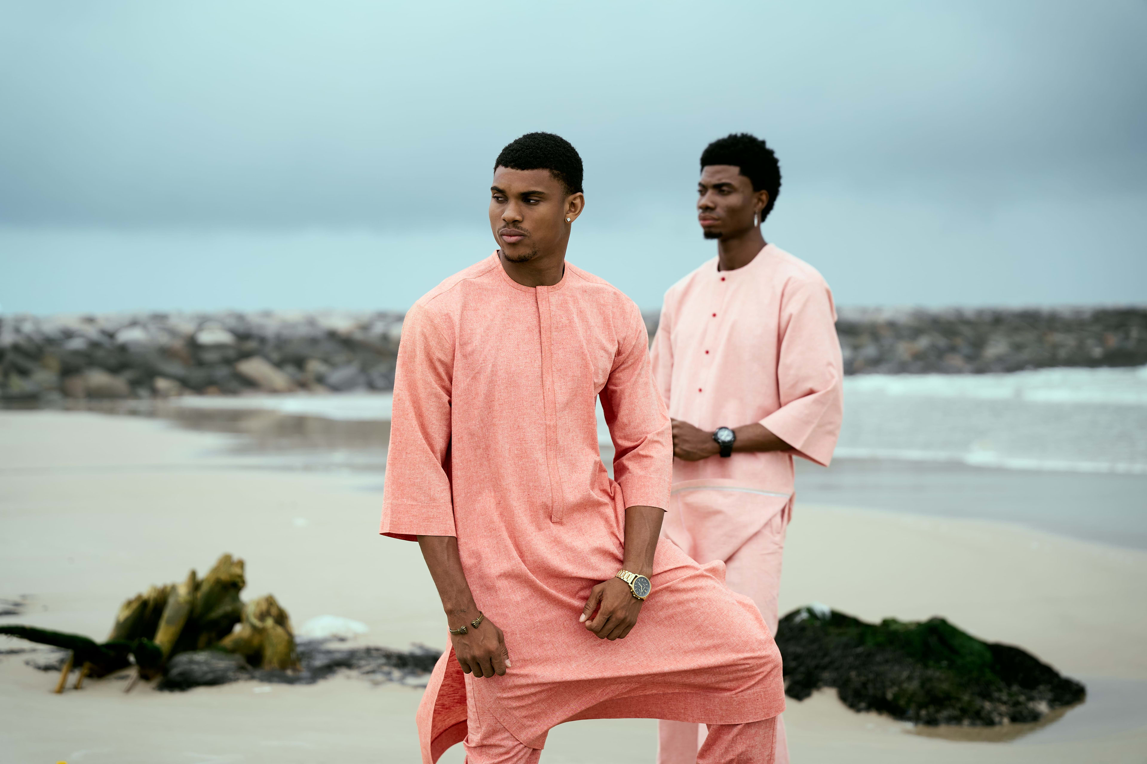 Two OnPoint models in matching coral two-piece sets, standing together on the beach