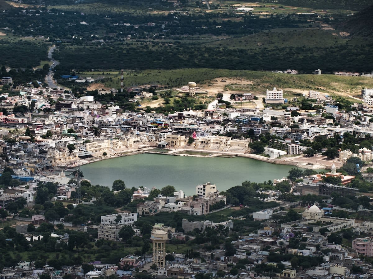 Pushkar from above — the lake, the ghats and the white-walled town packed around them