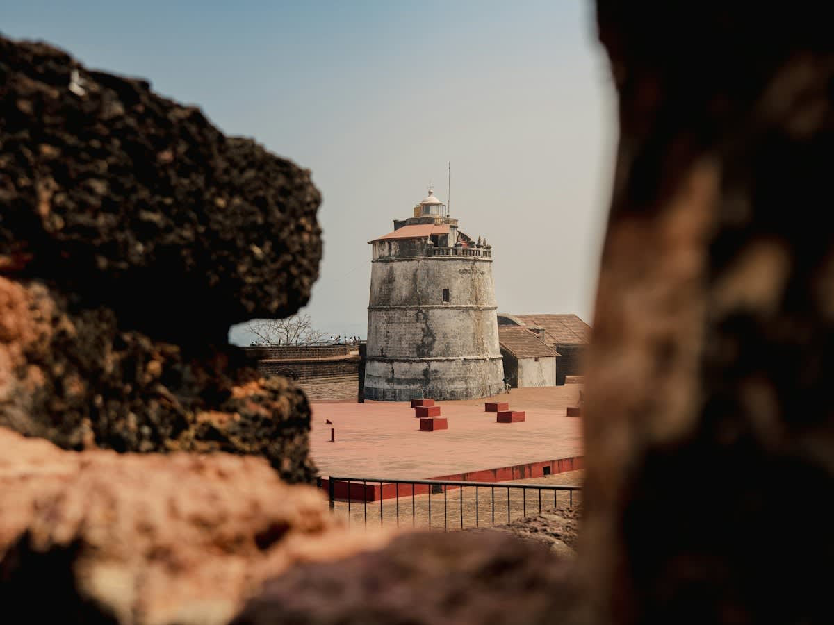 Fort Aguada's lighthouse seen through the rock — the headland has guarded the Mandovi river for four centuries
