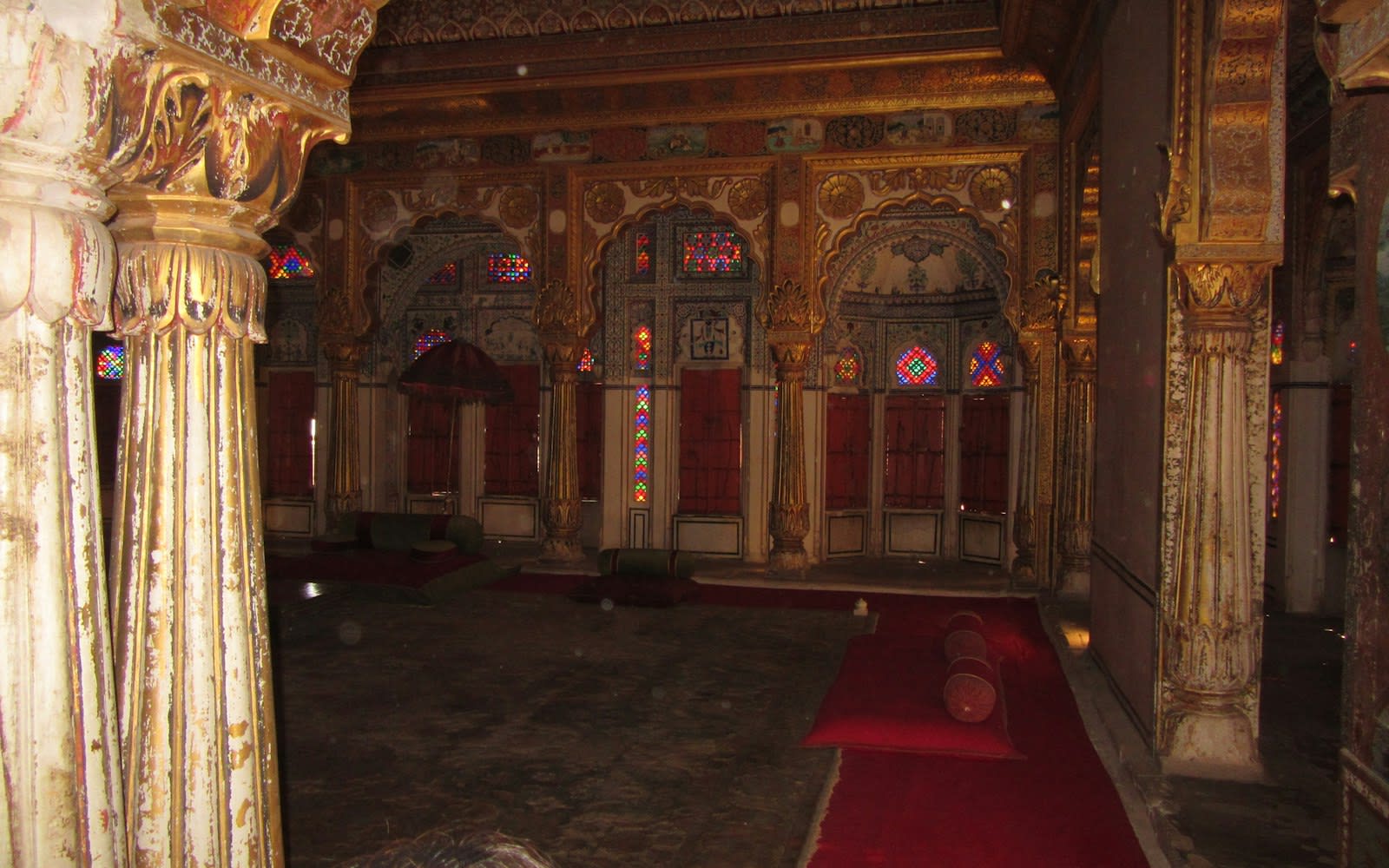 A pillared hall with a red carpet inside Mehrangarh Fort