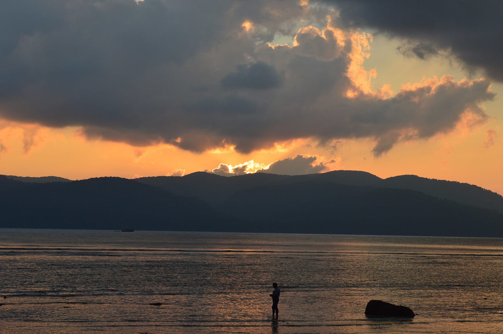 Sunset glow behind dark hills over the shore at Chidiya Tapu, South Andaman