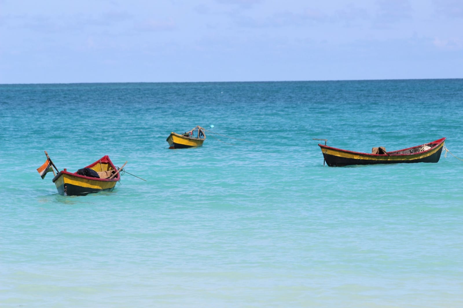Small painted boats on turquoise water off Kalapathar Beach