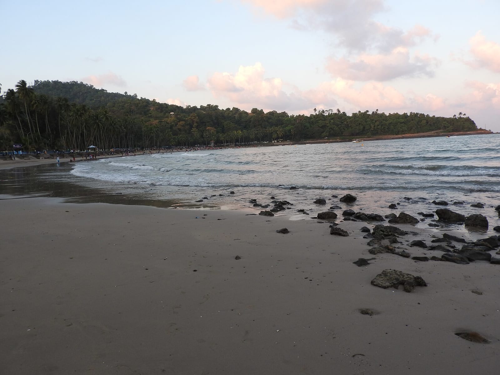 Corbyn's Cove beach, Port Blair, with a dark rocky shore and forest