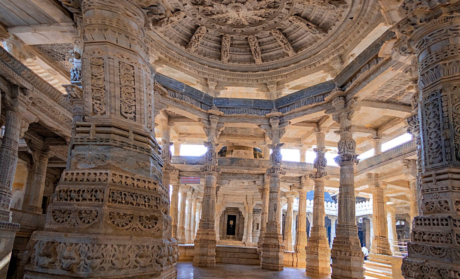 Carved marble pillars and a domed ceiling inside the Ranakpur Jain temple