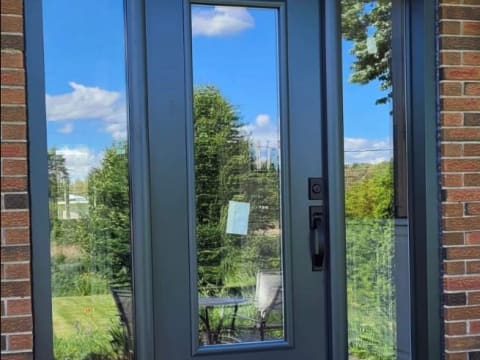 Porte d'acier contemporaine noire à vitrage pleine hauteur avec deux latéraux