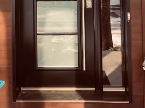 Porte d'acier contemporaine brune à verre décoratif et poignée longue avec un latéral