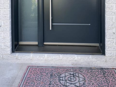 Porte d'acier contemporaine noire à rainures et poignée longue avec un latéral givré