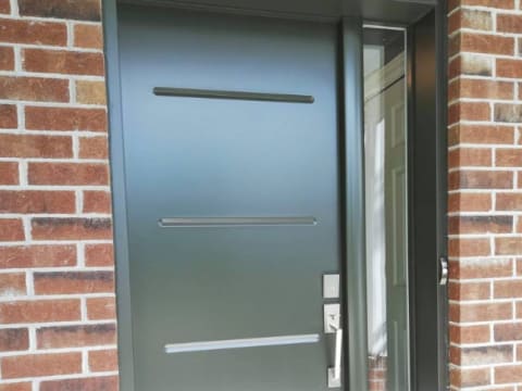 Porte d'acier contemporaine noire à rainures horizontales avec un latéral vitré