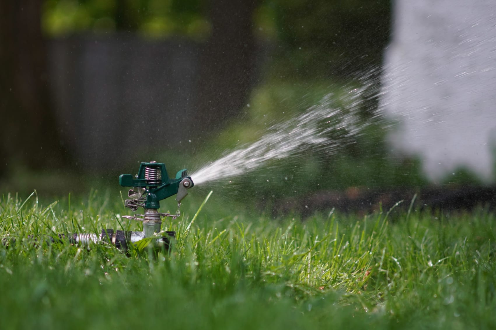 Impact sprinkler watering a green lawn