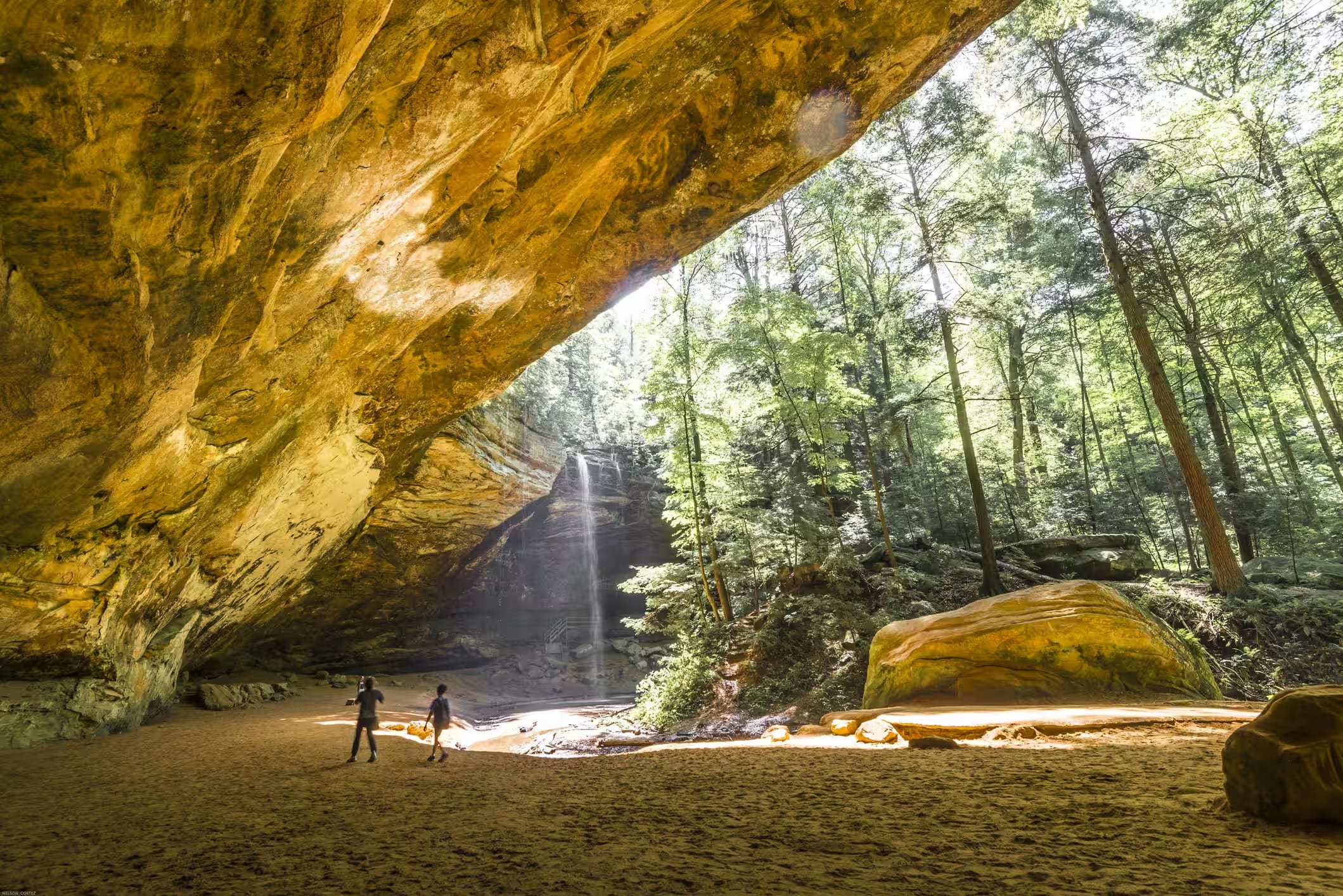 The wide sandstone recess of Ash Cave in Hocking Hills State Park, with its horsetail waterfall falling from the rim