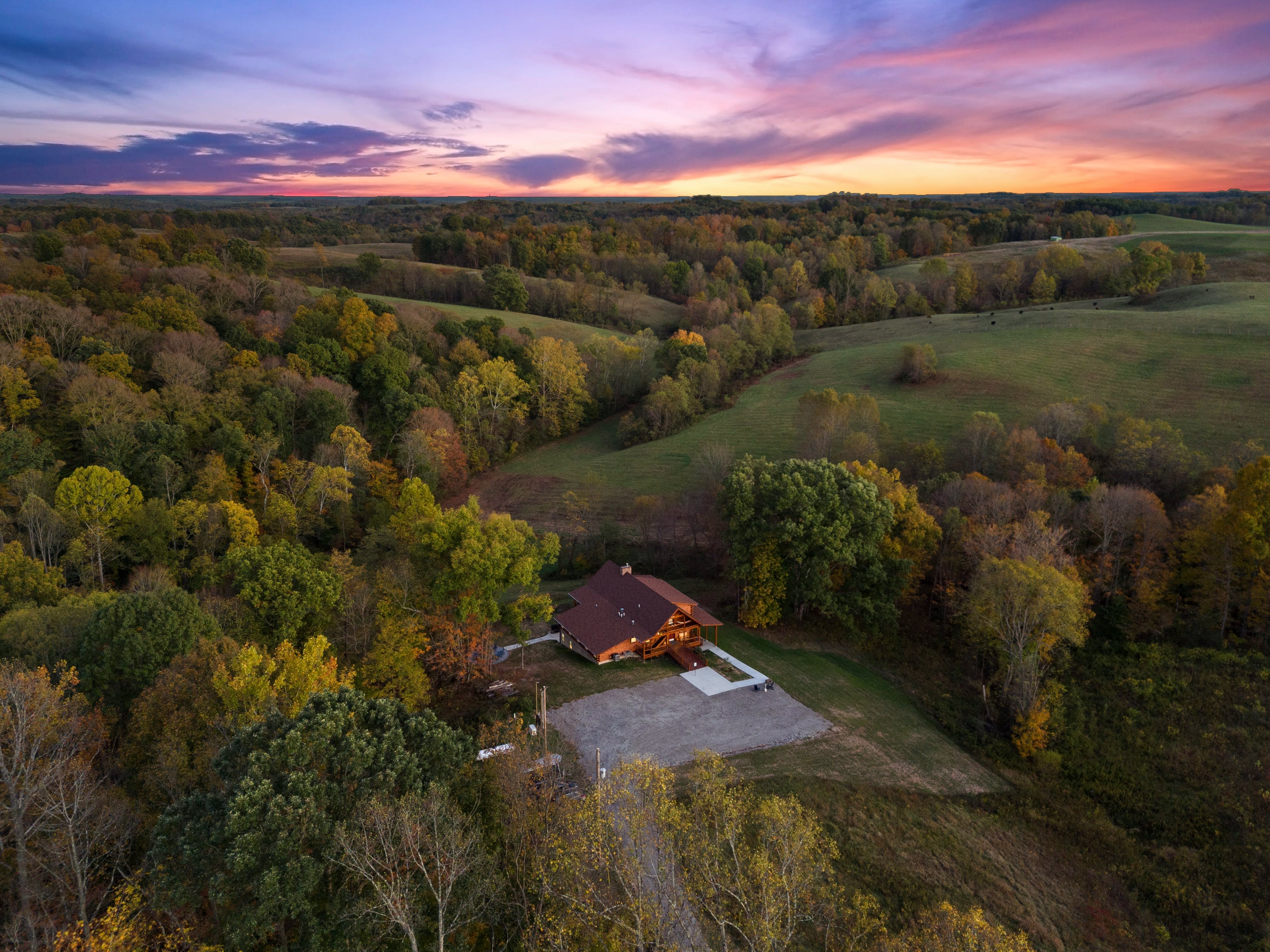 Aerial drone view of Pool House Lodge's 22 private wooded acres in Hocking Hills, Ohio at sunset