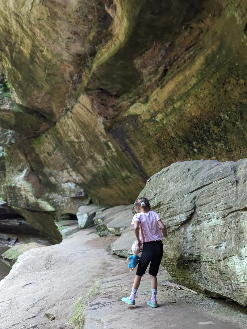 A child beneath a towering sandstone overhang at Old Man’s Cave.