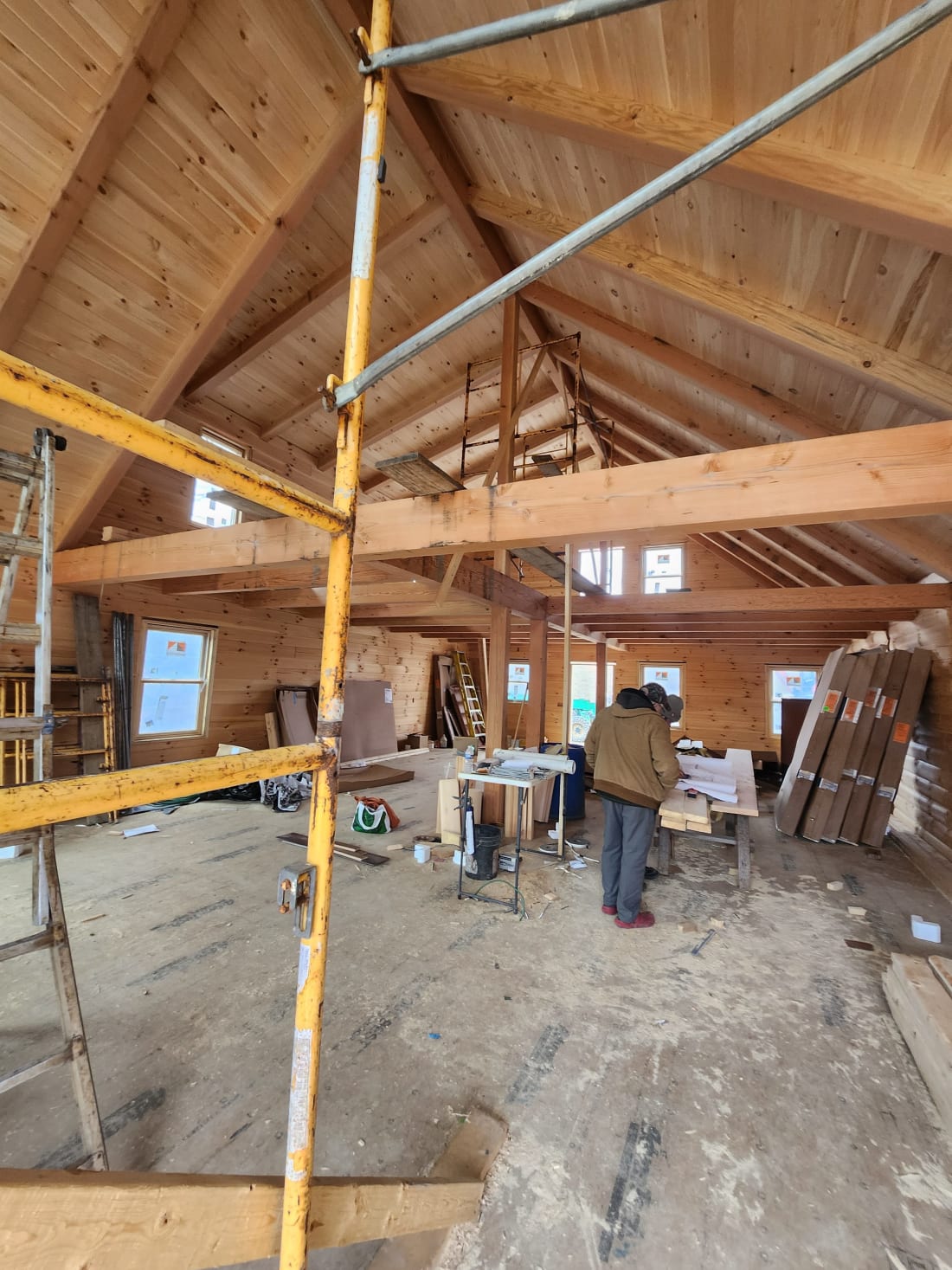 Interior of Pool House Lodge during construction — exposed beams, loft framing, and cathedral ceiling