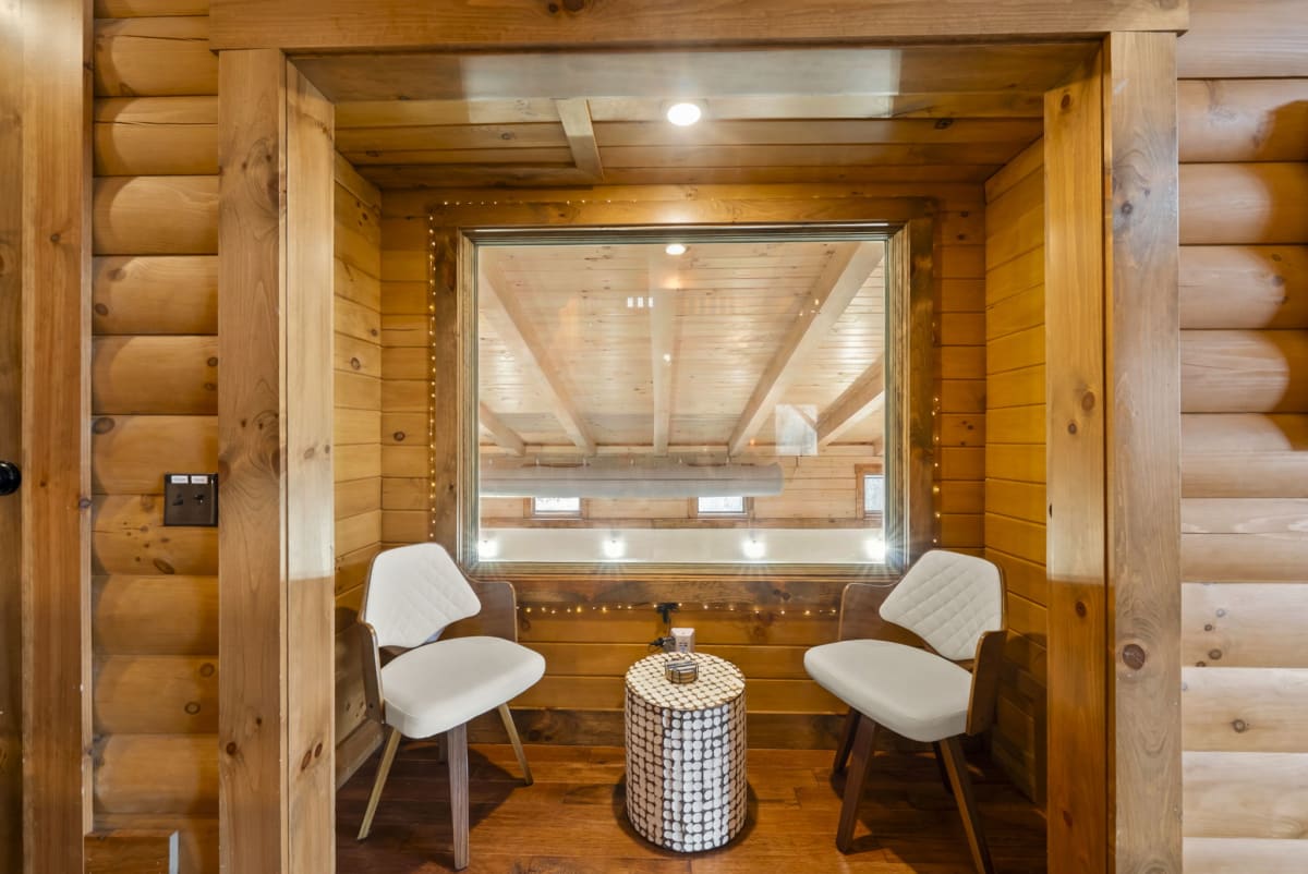 The grandparent's nook at Pool House Lodge — white chairs looking through window directly into the indoor pool, Hocking Hills Ohio