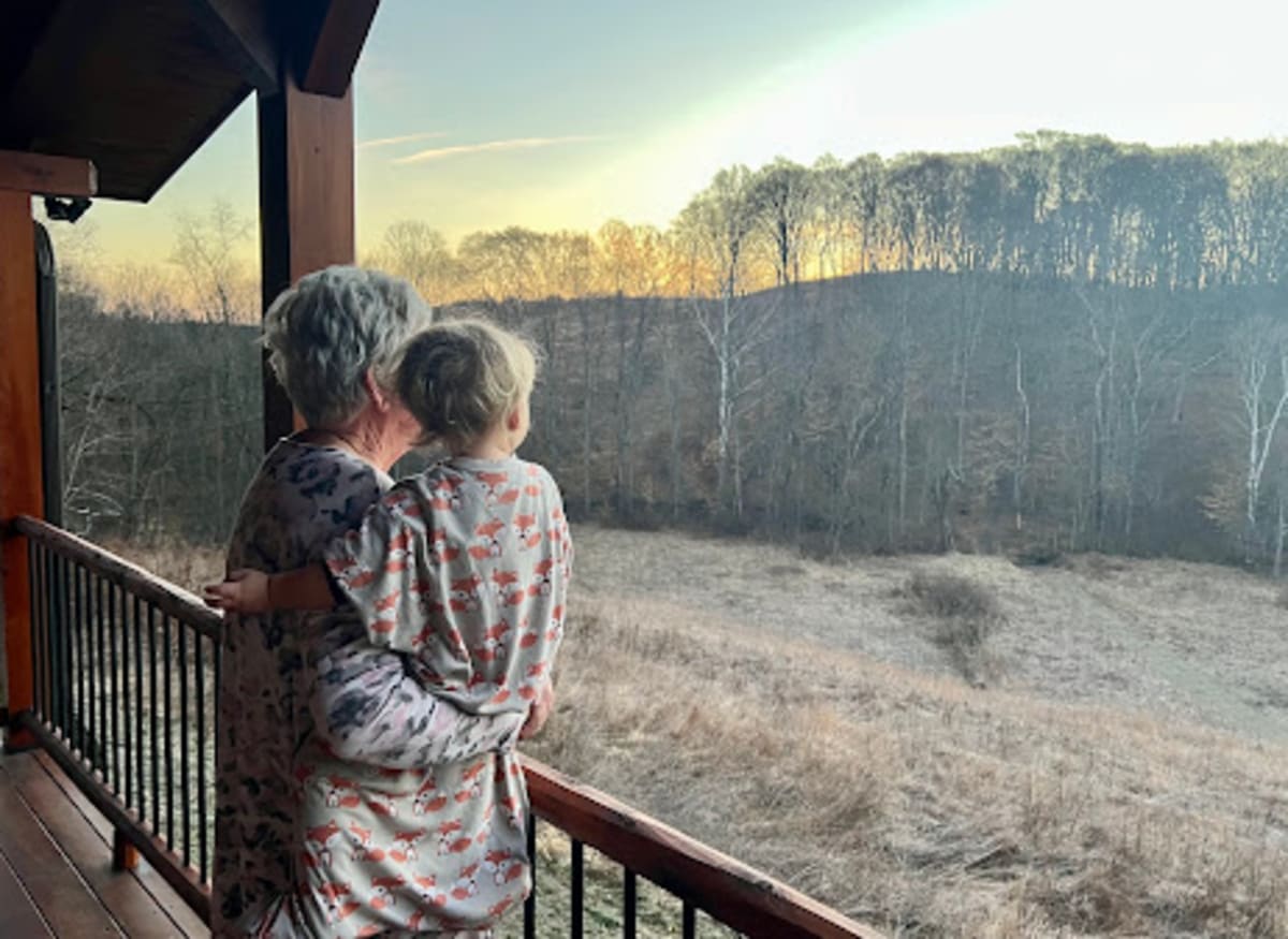 Grandmother and grandchild on the deck at sunrise at Pool House Lodge — multigenerational family cabin in Hocking Hills Ohio