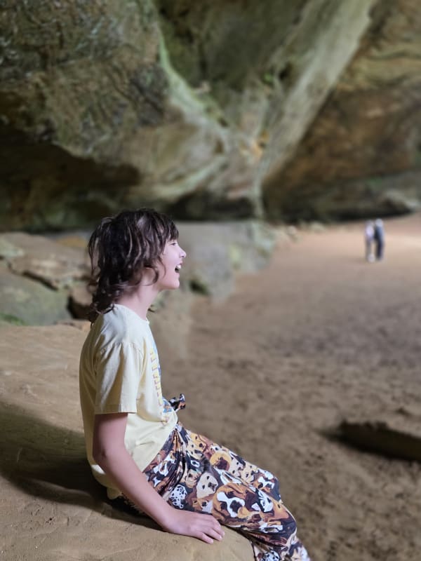 Ash Cave interior Hocking Hills Ohio — sandy cave floor with waterfall visible in background