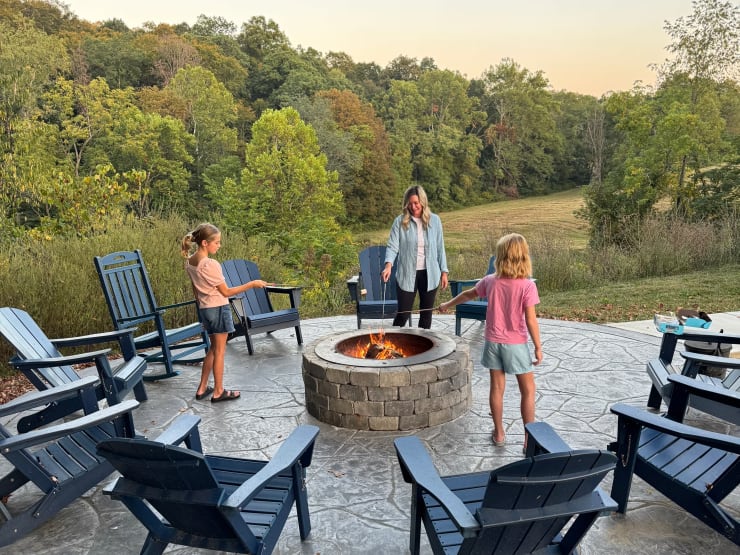 Family at fire pit at Pool House Lodge