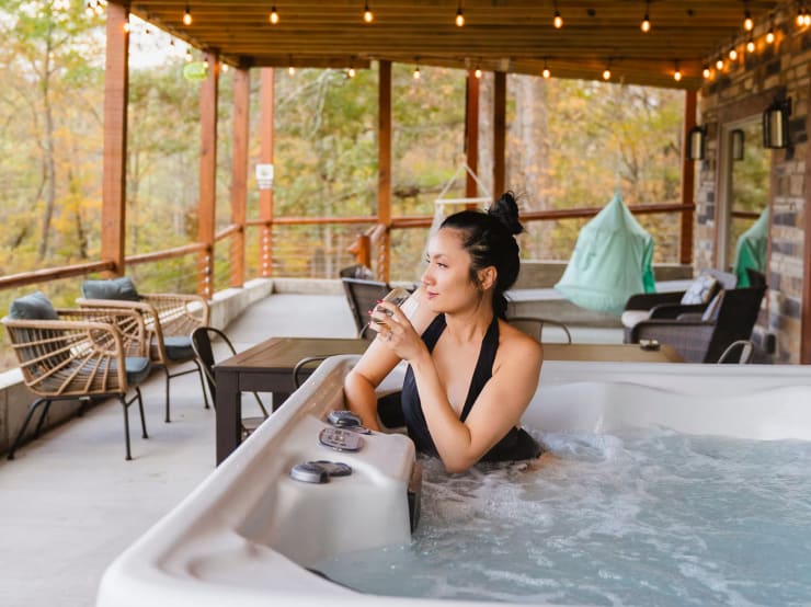Guest relaxing in hot tub at Pool House Lodge