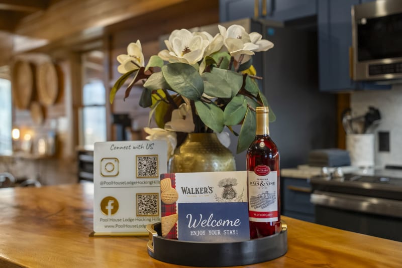 Pool house lodge kitchen welcome wine flowers counter