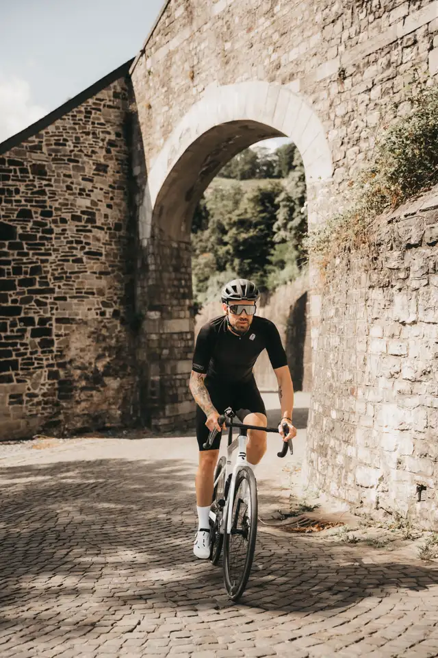 Ciclista bajo arco de piedra