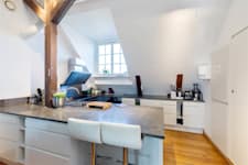 Östermalmsgatan 87 D - Kök med köksö i sten och barstolar.