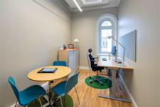 Linnégatan 89 A - Rum med mindre mötesbord och skrivbord för arbete.