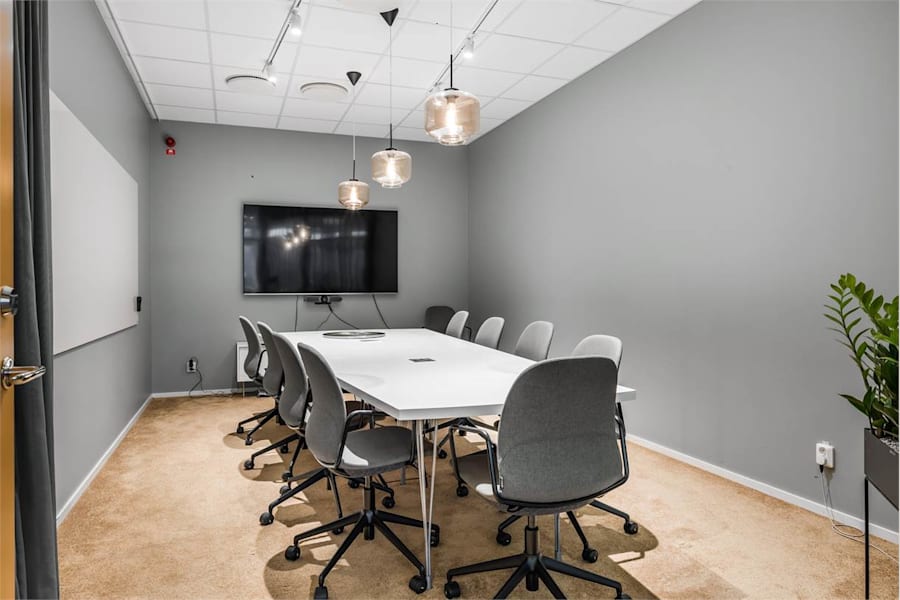 Sveavägen 163 - Mötesrum med trägolv och grå väggar.