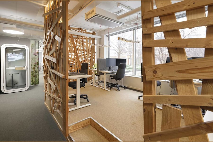 Rådmansgatan 16 - Arbetsplatser med trädetaljer intill mötesbås med glasdörr.