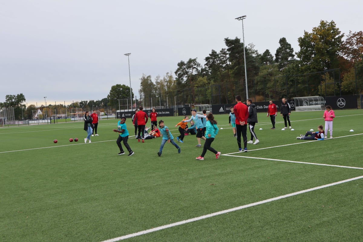 Children and coaches on a soccer field engage in playful activities.