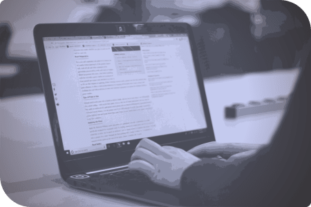 Una persona está usando un laptop en una mesa.
