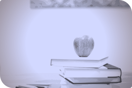 Un libro y una manzana en una pila.