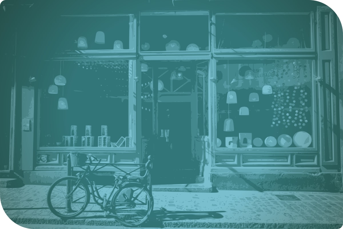 Una bicicleta está parada en la calle frente a una tienda.