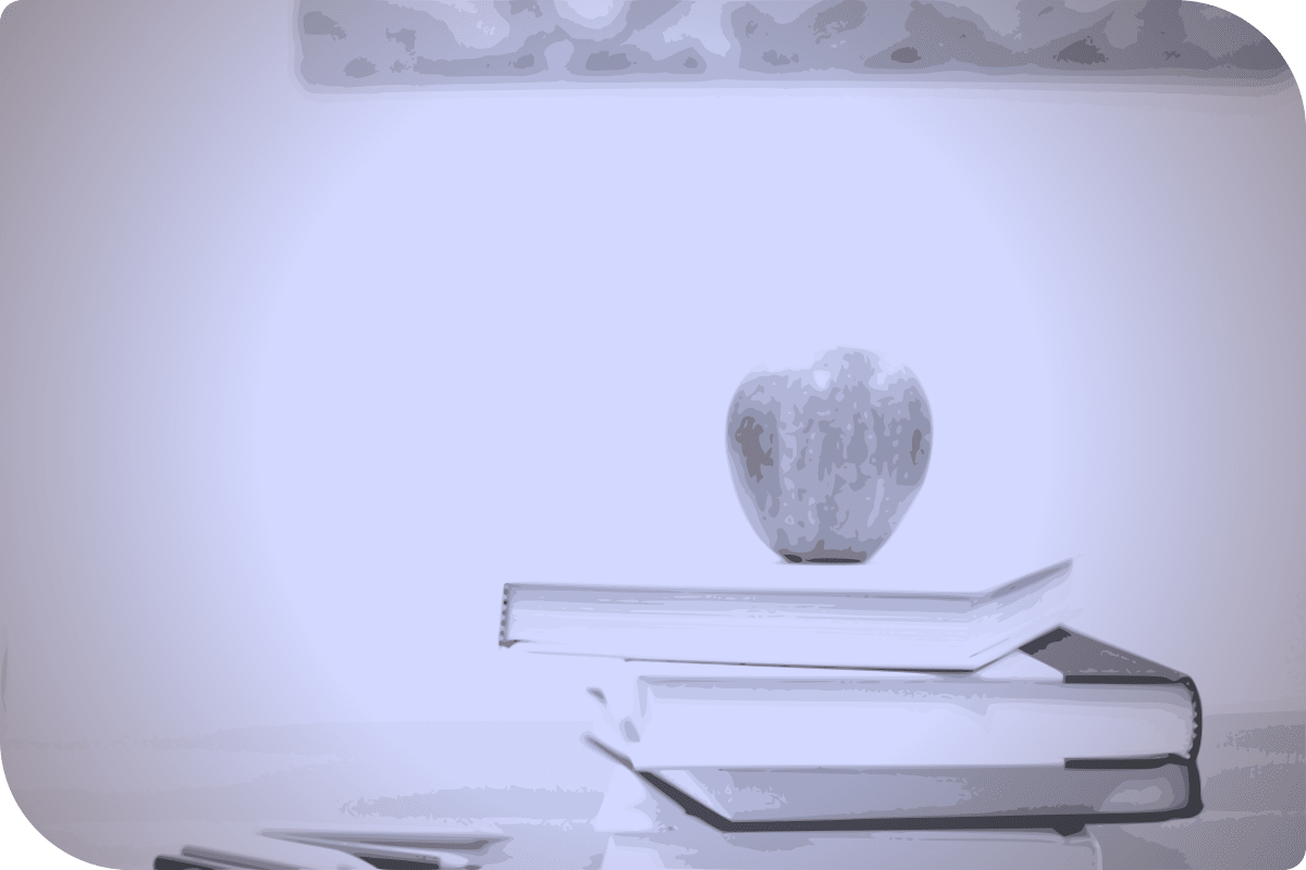 Un libro y una manzana en una pila.