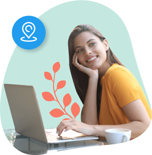 Una mujer joven sonriendo mientras usa su computadora.