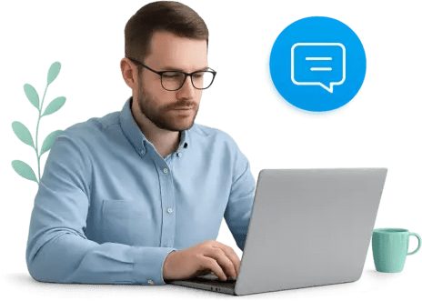 Un hombre con gafas y un shirt azul, usando un laptop.