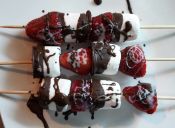 Prepara brochetas de frutilla, chocolate y marshmallow