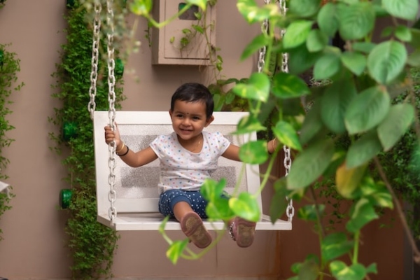 Niña en un columpio en su casa