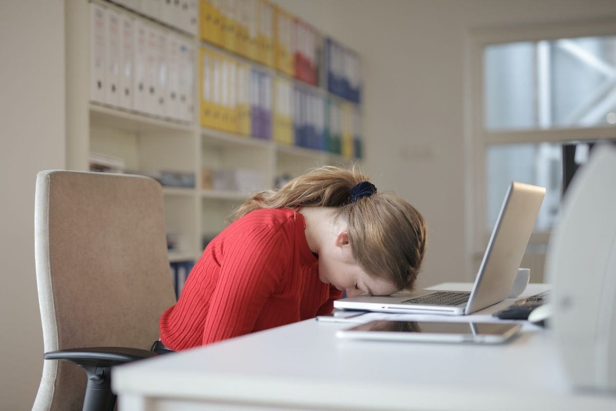 Mujer cansada frente al computador. 