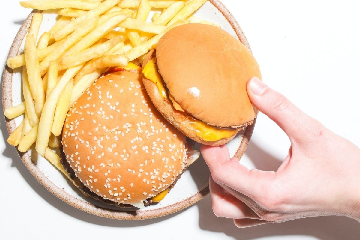 Plato de comida con hamburguesa y papas fritas. 