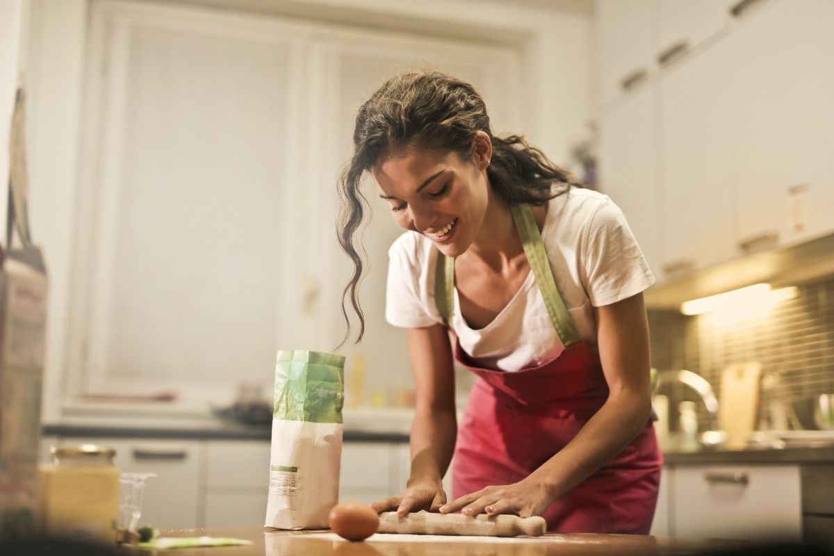 Mujer prepara comida en su cocina. 