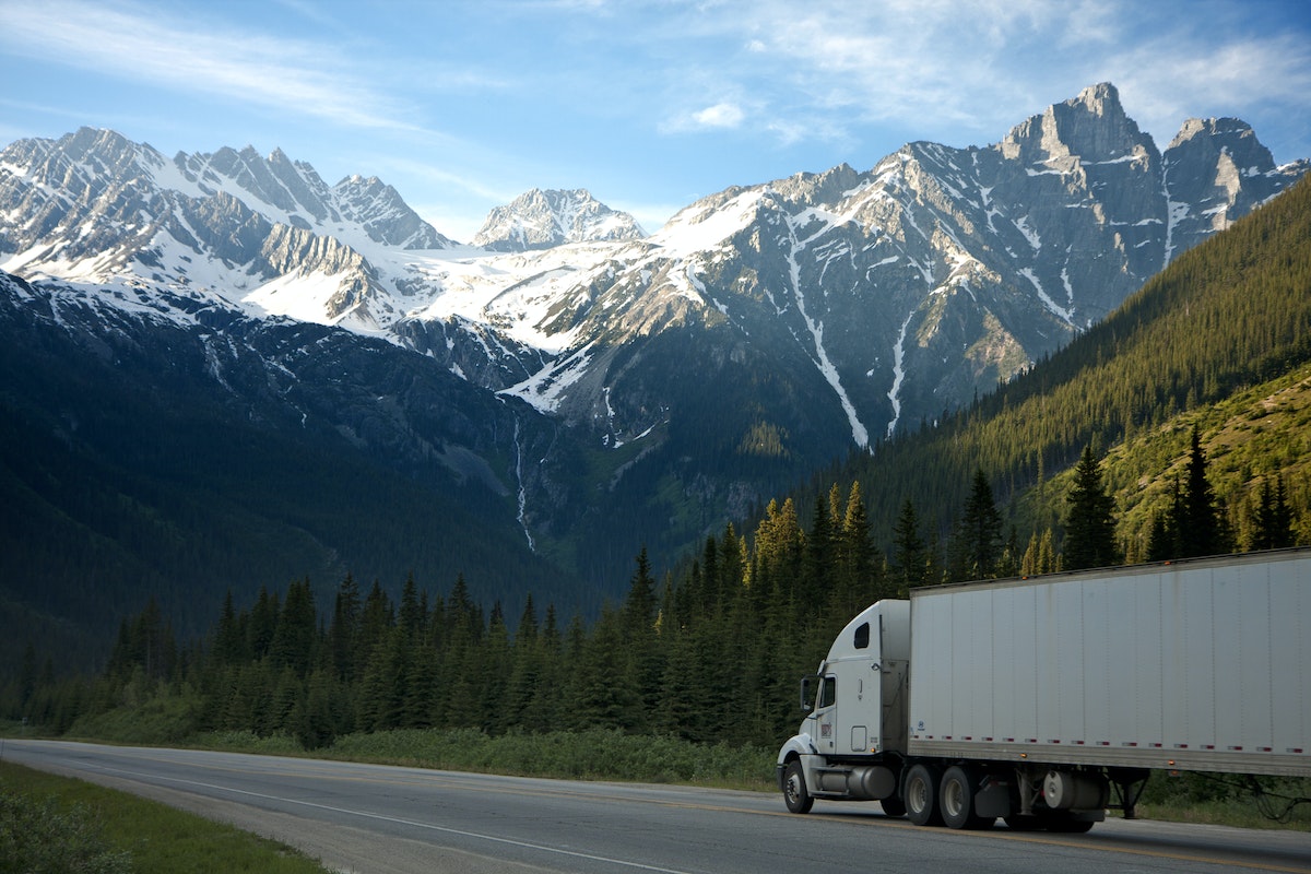 A white truck in the middle of its route, transporting its cargo, followed by vehicle tracking software