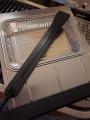 Slide-out catch pan with disposable drip pan and scraper