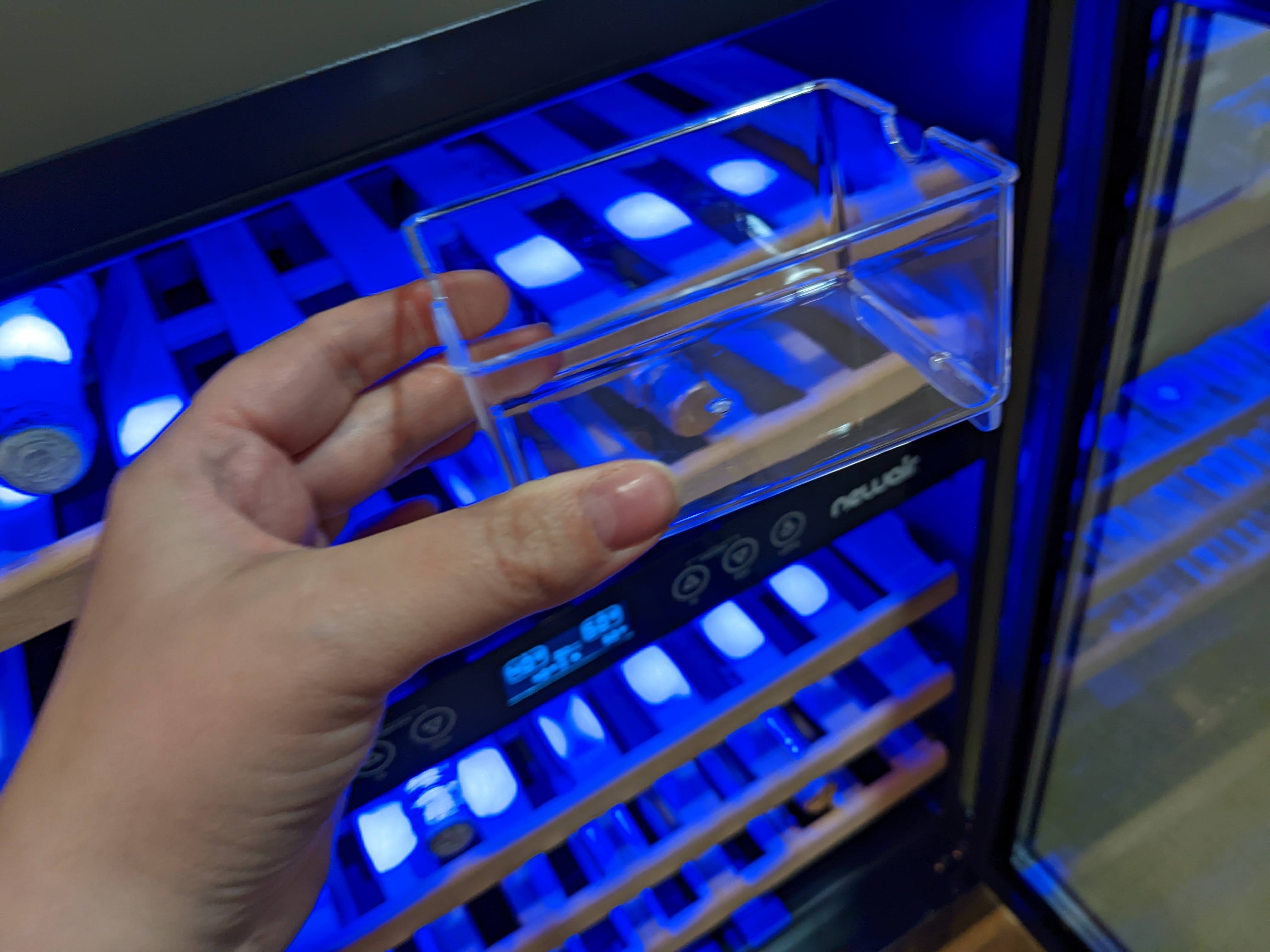 The clearc cup can be half filled with distilled water and placed anywhere in the fridge to add humidity inside which is good  for the wine corks.