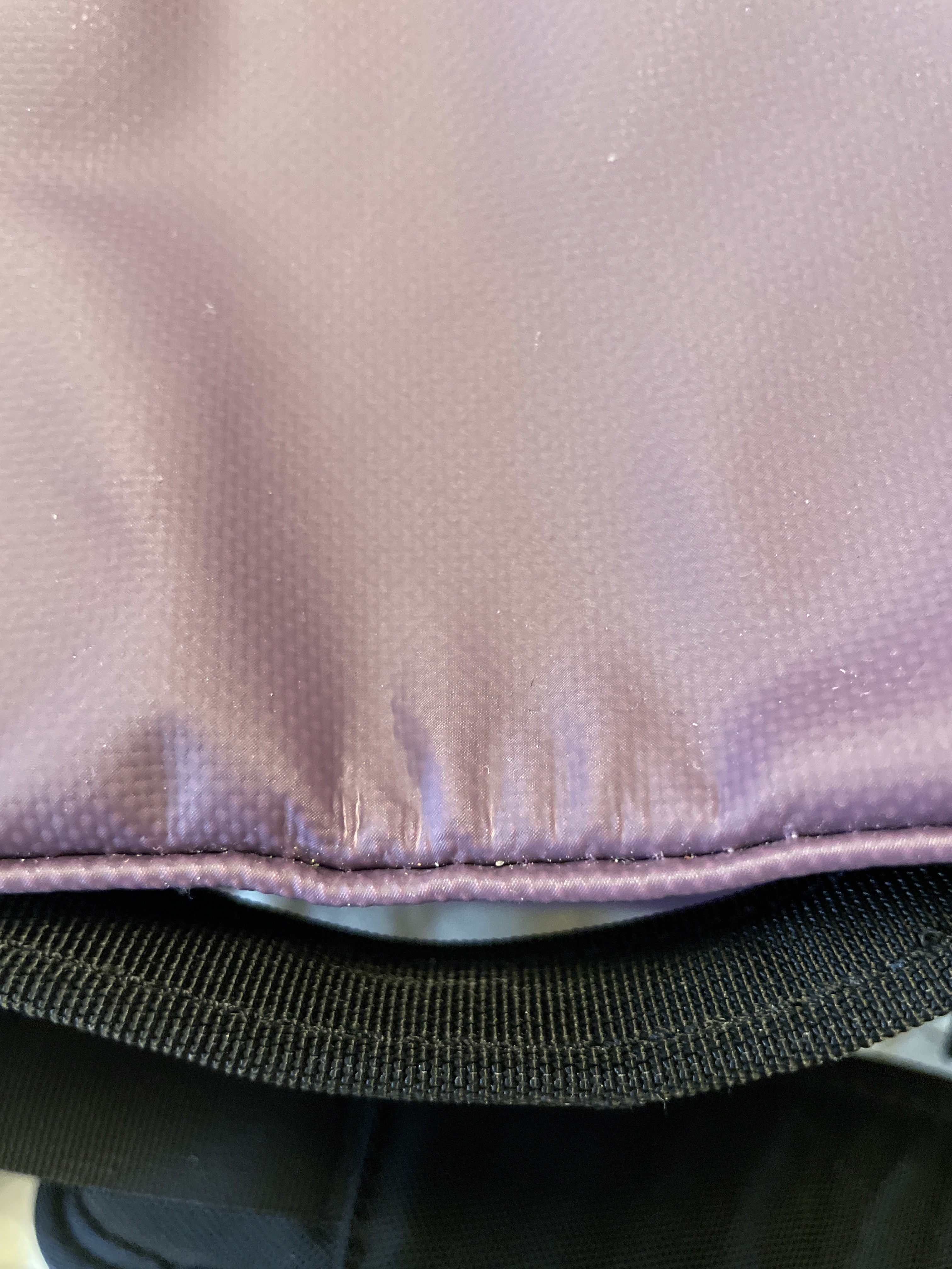 Stretching along seam on top of bag.