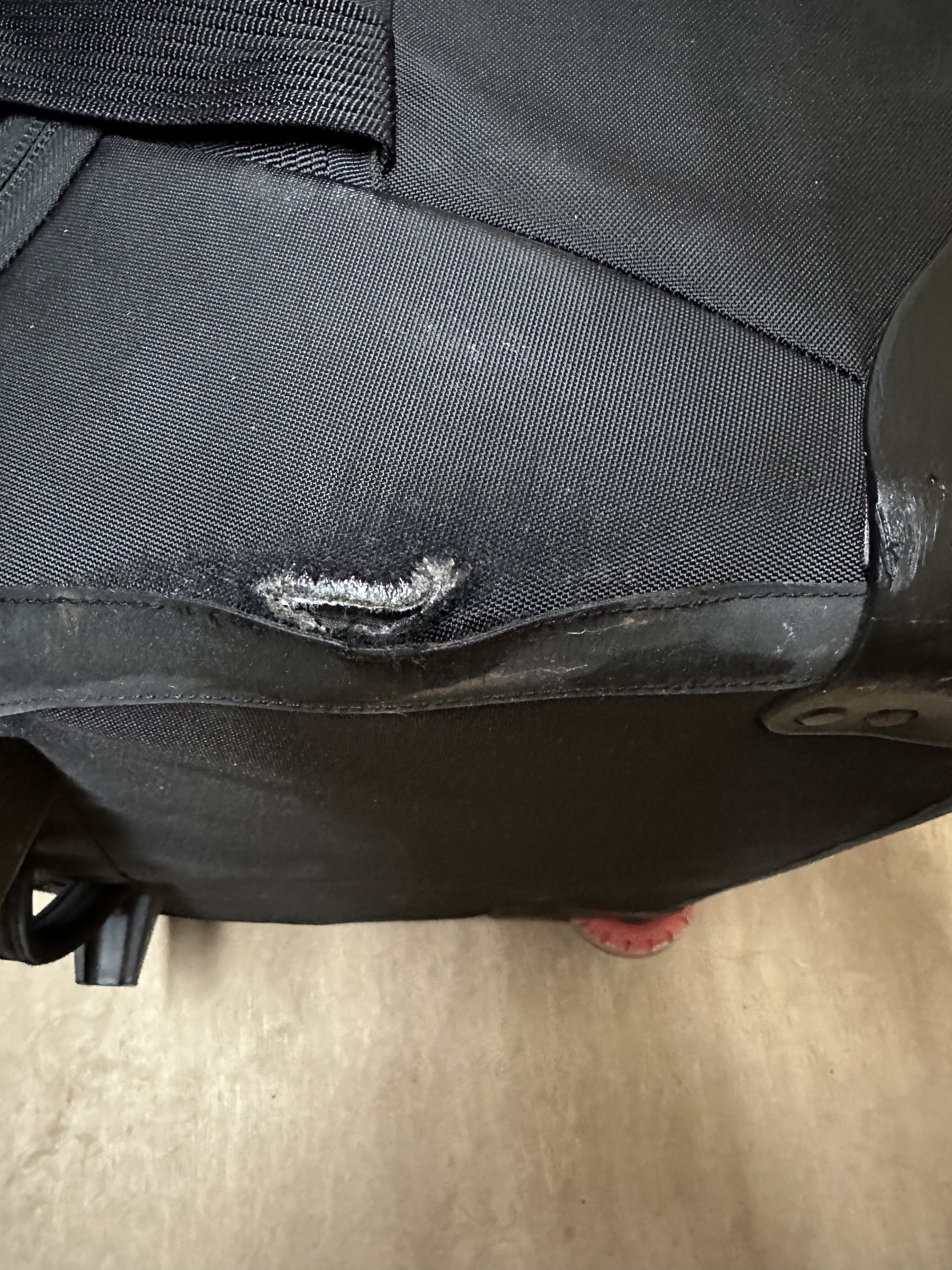 A hole in the bottom of the bag; stitching coming apart