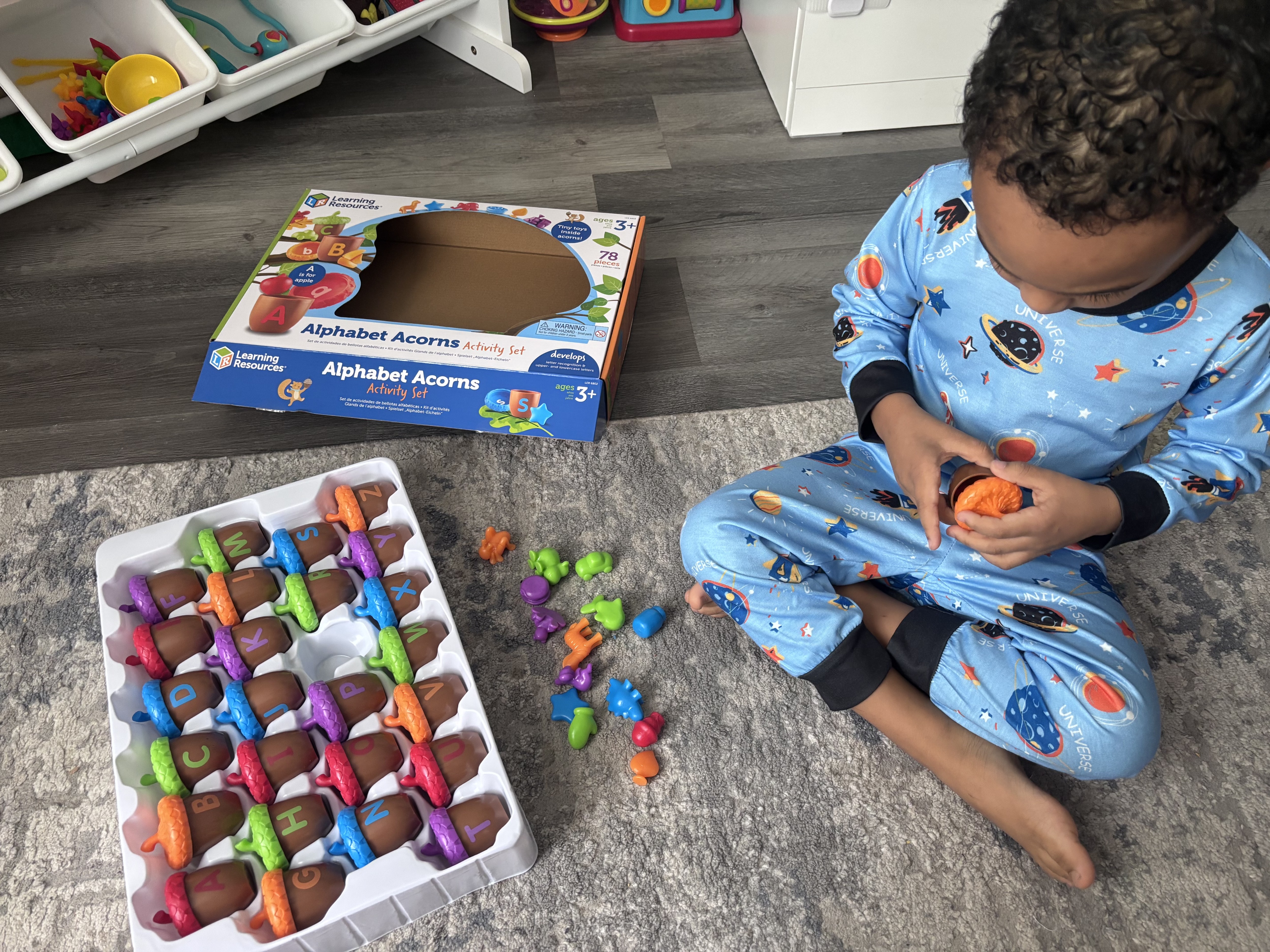 Each acorn hides a surprise object that matches the letter. He loves discovering them!