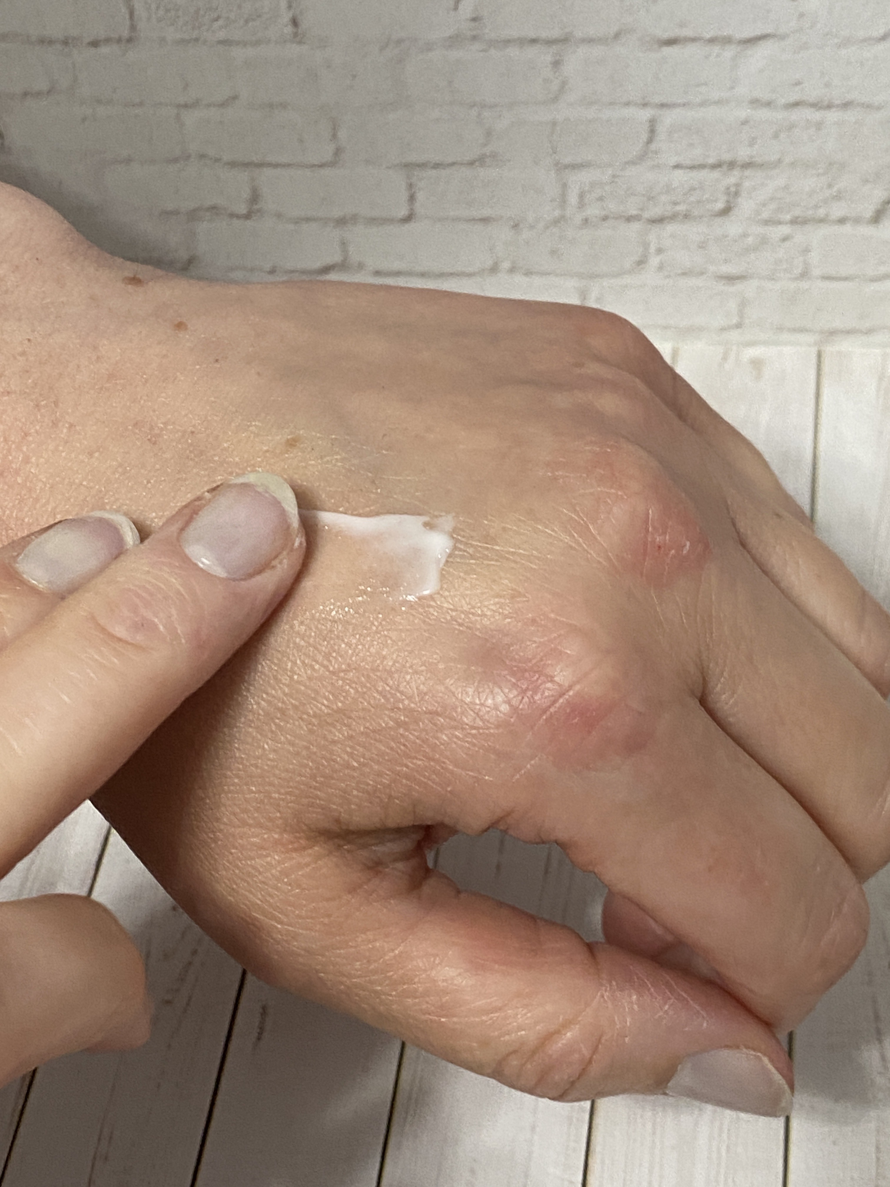 Applying Clé de Peau Advanced Intensive Night Cream on hand for demonstration