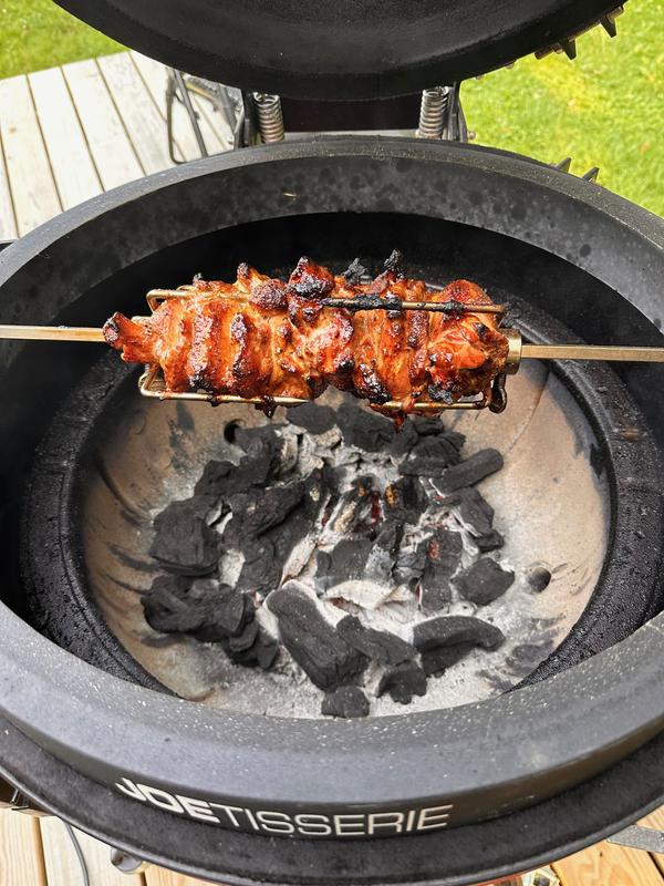 Seasoned chicken thighs slow rotating over hot coals - JoeTisserie is the way!
